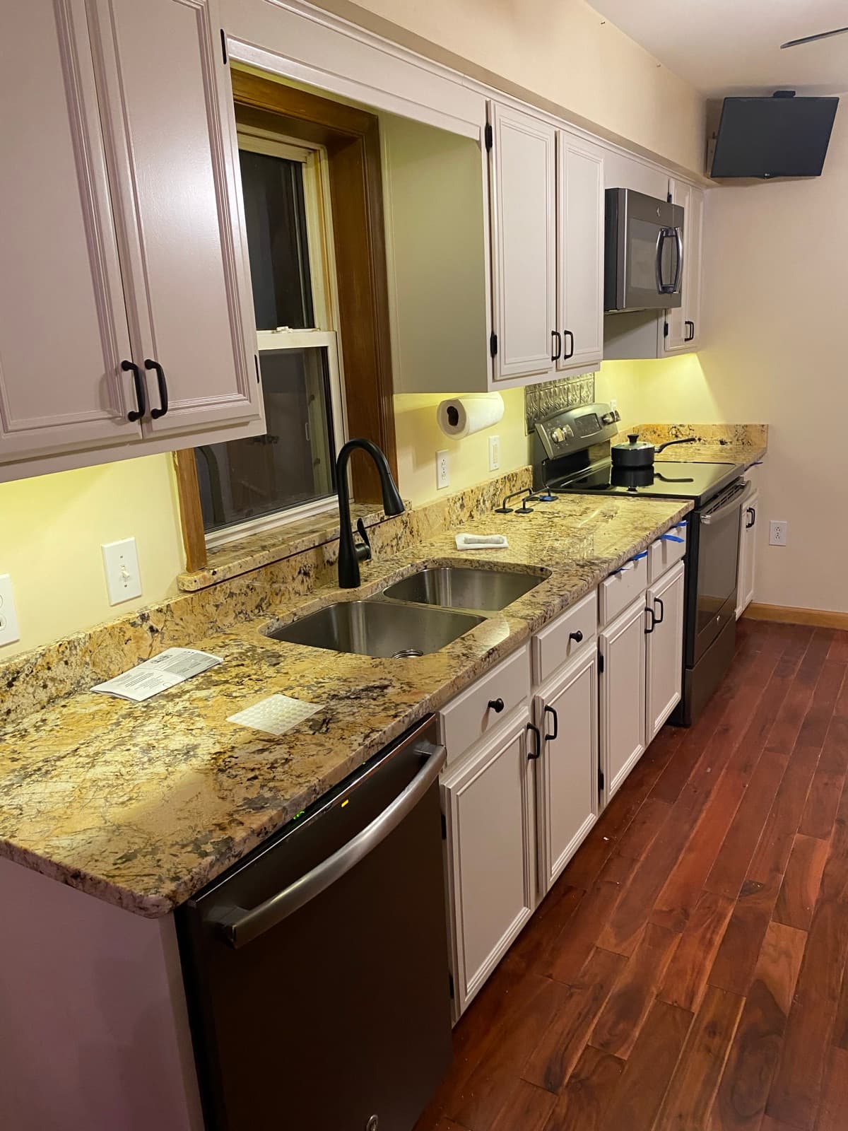 Refinished cabinets and granite counters at the sink wall