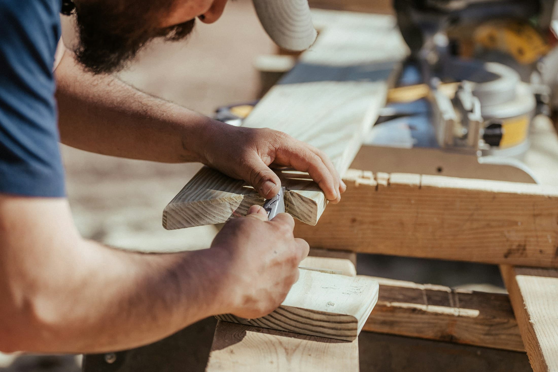 Close-up of a carpenter marking a wood joint in a workshop